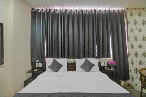 a bedroom with a large bed with black curtains at OYO Townhouse Green park Residency 3 in New Delhi