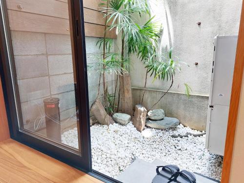 une porte vitrée avec un jardin à l'extérieur d'un bâtiment dans l'établissement Kamogawa Sanpo, à Shimmachidōri