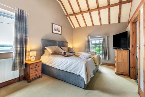 a bedroom with a large bed and a television at Willerby Grange Farm in Willerby