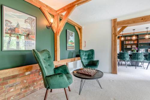 a living room with green chairs and a table at Criol Oast in Shadoxhurst