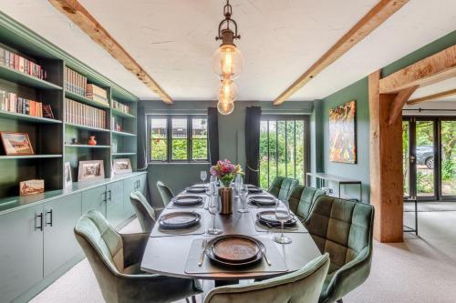 a dining room with a long table and chairs at Criol Oast in Shadoxhurst