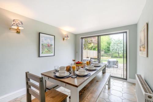 a dining room with a table and a large window at Criol Oast in Shadoxhurst