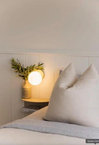 a bed with a pillow and a light on it at The Ridge in Burnt Pine