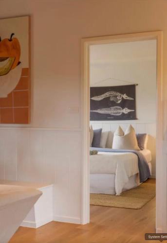 a bedroom with a white bed and a mirror at The Ridge in Burnt Pine