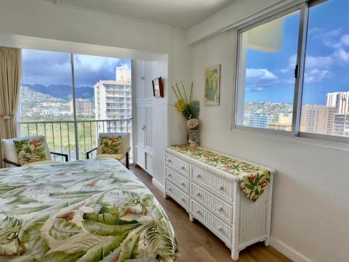 a bedroom with a bed and a large window at Jenny's Cottage Waikiki in Honolulu
