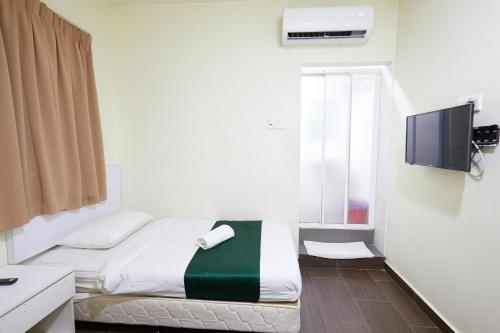 a small bedroom with a bed and a tv at Fast Hotel Sri Gombak in Batu Caves