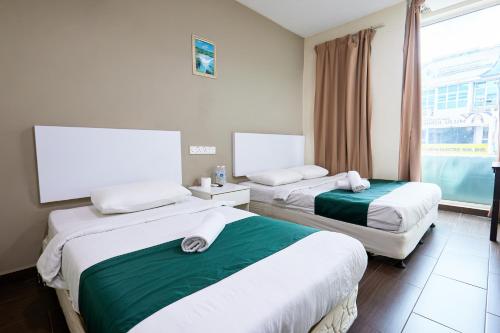 a hotel room with two beds and a window at Fast Hotel Sri Gombak in Batu Caves