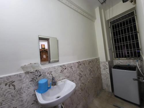 a bathroom with a sink and a mirror on the wall at A Cozy home away from home! in Hyderabad