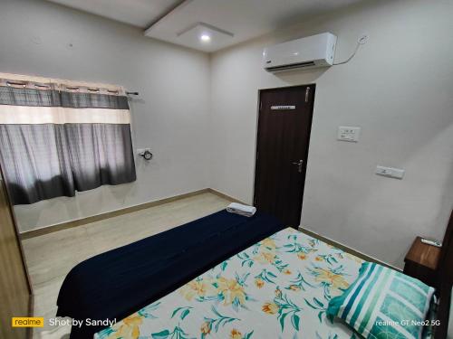 a small room with a bed and a window at A Cozy home away from home! in Hyderabad