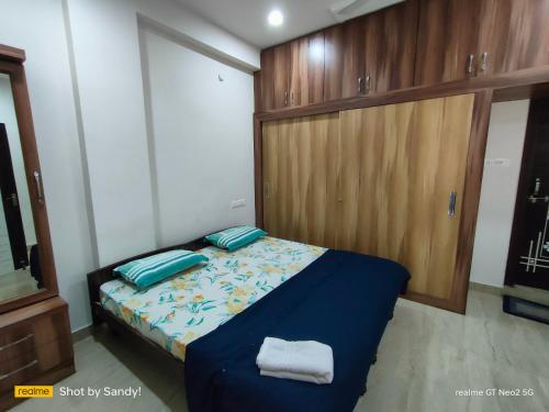 a bedroom with a bed and a wooden cabinet at A Cozy home away from home! in Hyderabad