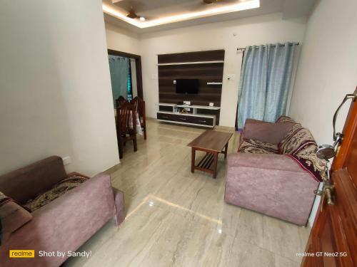 a living room with two couches and a tv at A Cozy home away from home! in Hyderabad