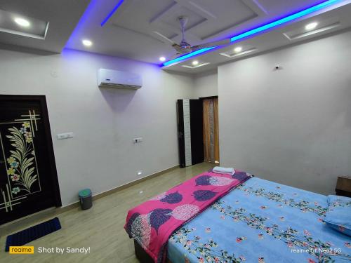 a bedroom with a bed in a room with blue lights at A Cozy home away from home! in Hyderabad