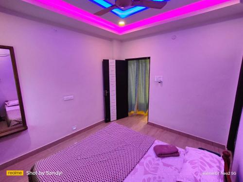 a room with a purple room with a bed and a mirror at A Cozy home away from home! in Hyderabad