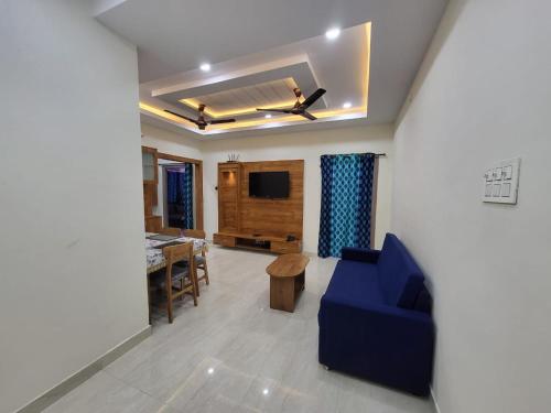 a living room with a blue couch and a table at A Cozy home away from home! in Hyderabad