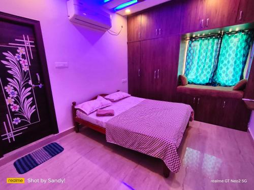 a bedroom with a bed in a purple room at A Cozy home away from home! in Hyderabad