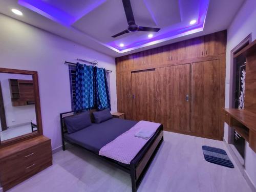 a bedroom with a bed and a mirror and a tv at A Cozy home away from home! in Hyderabad