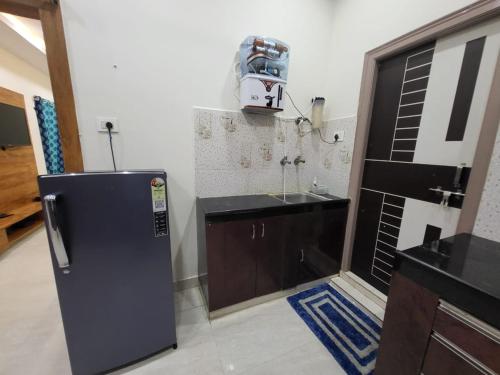 a kitchen with a black refrigerator and a sink at A Cozy home away from home! in Hyderabad