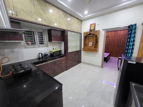 a kitchen with wooden cabinets and a counter top at A Cozy home away from home! in Hyderabad