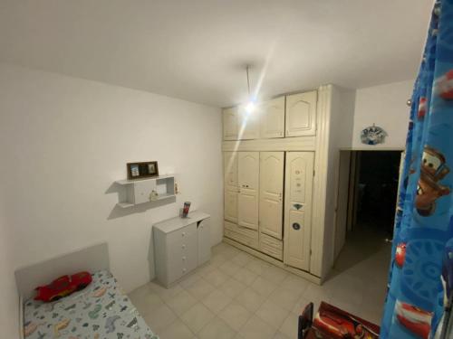 1 dormitorio con armarios blancos y 1 cama. en Cozy Apartment, 3 Bedrooms, en Praia
