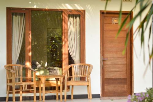 a table and chairs in front of a door at Maja House Penida in Nusa Penida