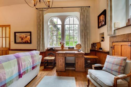a living room with a desk and a window at Monks Bridge in Crosby Ravensworth