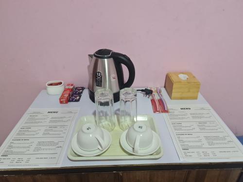 a table with a tea kettle and glasses on it at Room in Kapan, Near Boudhanath Stupa in Kathmandu