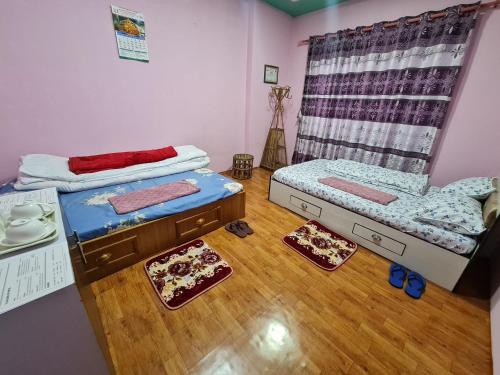 two beds in a room with wooden floors at Room in Kapan, Near Boudhanath Stupa in Kathmandu
