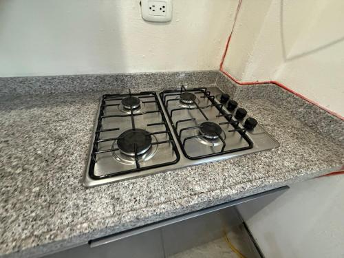 a stove top oven sitting on a granite counter top at Amanecer Entre Montañas in Las Granjas