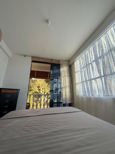 a bedroom with a large bed and a window at Amanecer Entre Montañas in Las Granjas