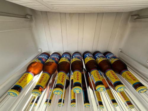 a refrigerator filled with lots of bottles of beer at Amanecer Entre Montañas in Las Granjas