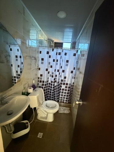 a bathroom with a toilet and a sink and a mirror at Amanecer Entre Montañas in Las Granjas