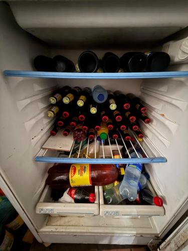 a refrigerator filled with lots of bottles of wine at Amanecer Entre Montañas in Las Granjas