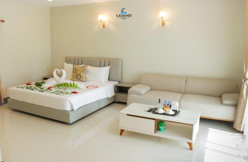 a hotel room with a bed and a couch at Legend Kep Resort in Kep