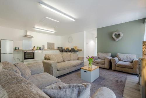 a large living room with couches and a kitchen at Magnolia - Bude in Bude
