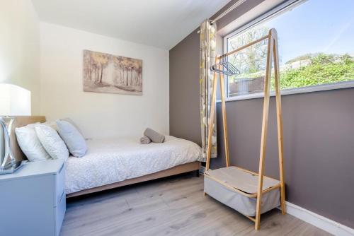 a small bedroom with a bed and a window at Magnolia - Bude in Bude