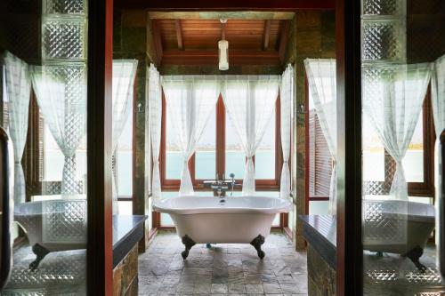 a bathroom with two sinks and a bath tub at Sun Siyam Olhuveli in South Male Atoll