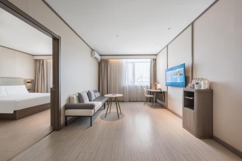 a hotel room with a bed and a couch at Hanting Hotel Beijing Fangshan Longhu Paradise Walk in Beijing