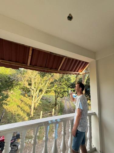 a man standing on a balcony looking out a window at Amanecer Entre Montañas in Las Granjas