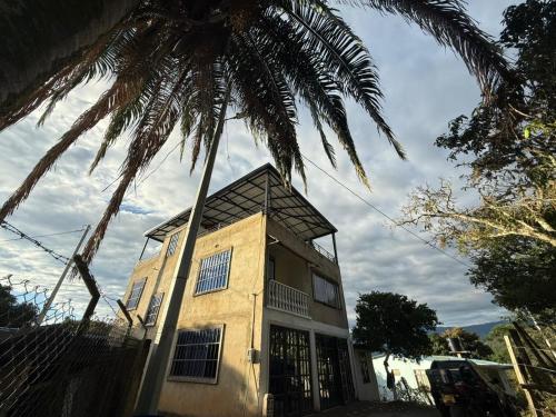 a palm tree in front of a building at Amanecer Entre Montañas in Las Granjas