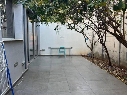 a table and a blue chair on a patio at Jedi Hub Hostel in Limassol