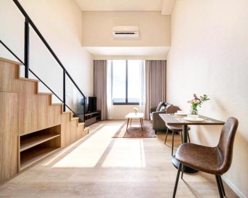 a living room with a staircase and a table and chairs at Siamese Residence Sukhumvit 87 Bangkok in Bangkok
