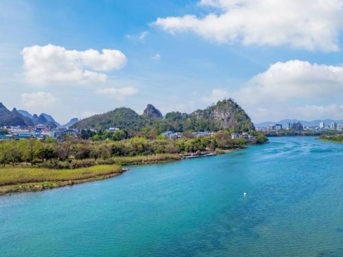 an aerial view of a river with mountains in the background at Lux CABINS一方山水 in Guilin