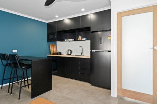 a kitchen with a black refrigerator and a table at Studio Four 