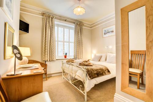 a bedroom with a bed and a desk and a mirror at 4 Pentyre House in Padstow