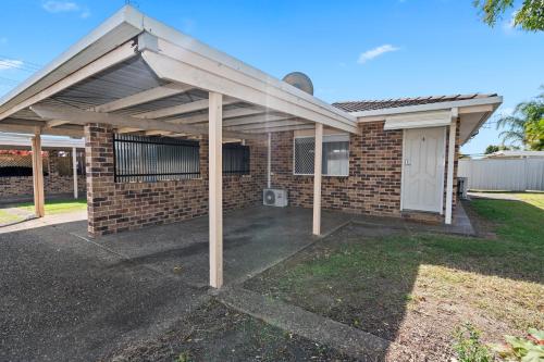 a brick house with awning over a driveway at Studio Four 