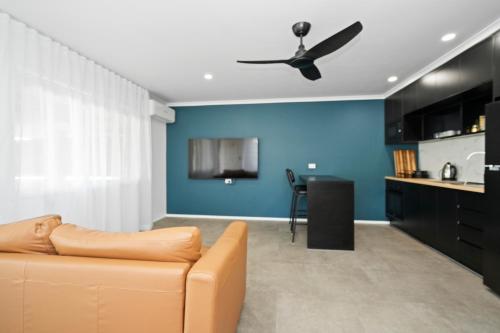 a living room with a couch and a ceiling fan at Studio Four 