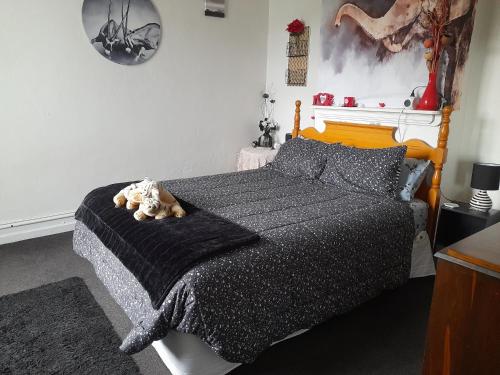 a bedroom with a bed with a teddy bear on it at Ellie's Villa in Brydone