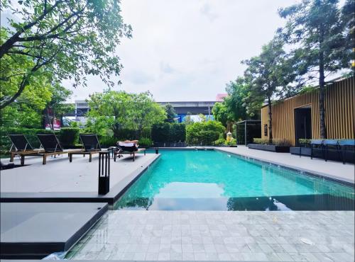 a swimming pool with two chairs and a table at Siamese Residence Sukhumvit 87 Bangkok in Bangkok