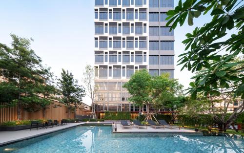 a swimming pool in front of a tall building at Siamese Residence Sukhumvit 87 Bangkok in Bangkok