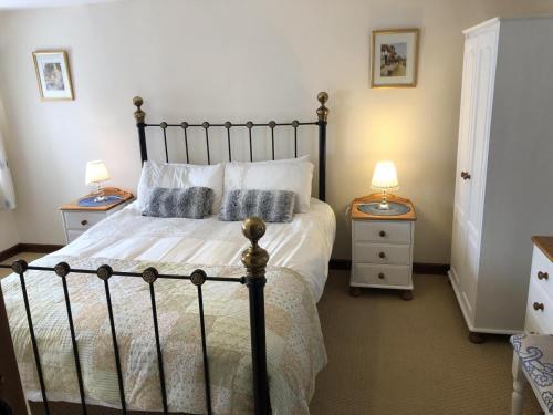 a bedroom with a large bed with two night stands at Woods Close at Sanctuary Farm in Kilkhampton
